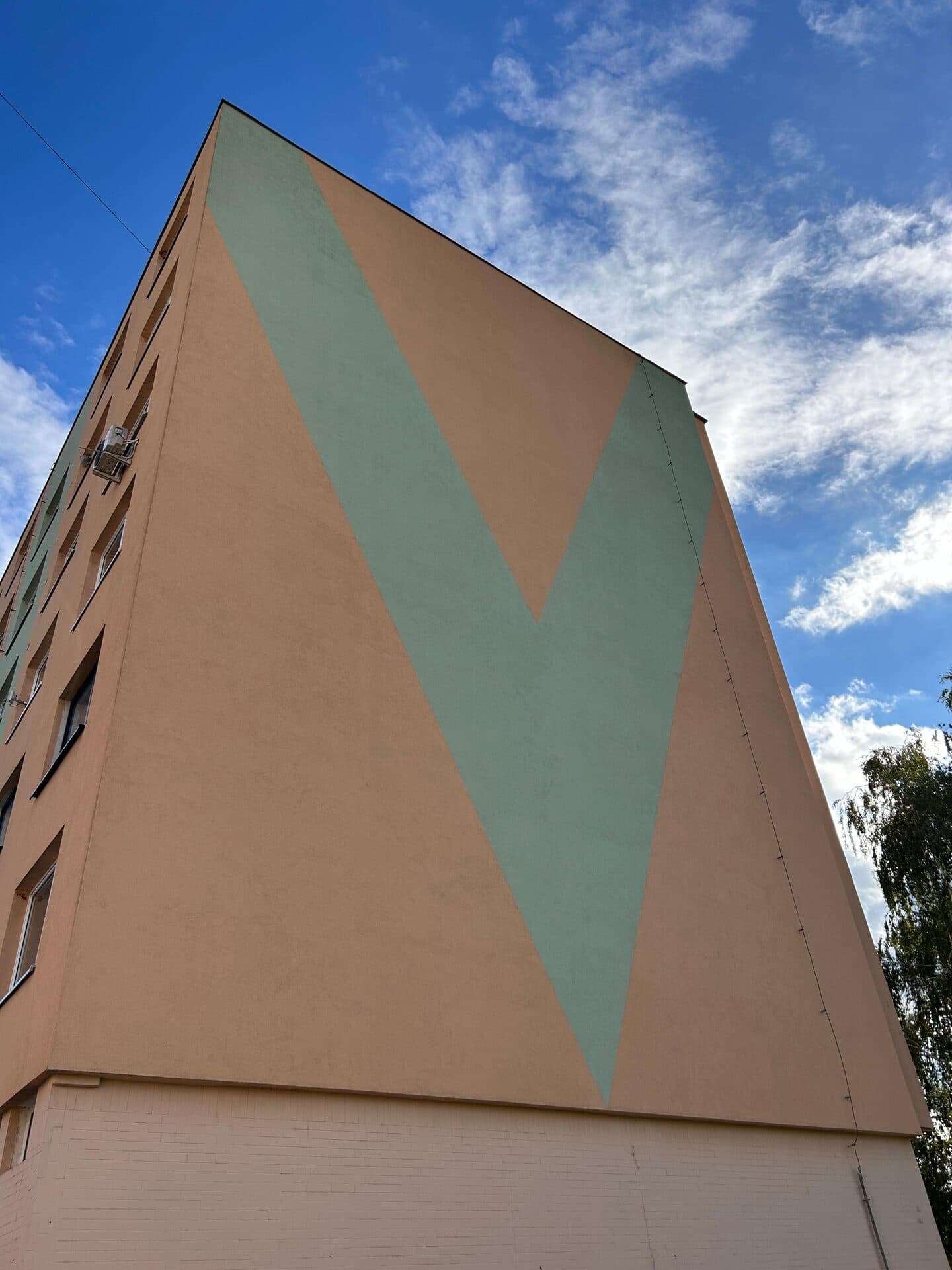 Vyčistená fasáda paneláku, slnečná obloha