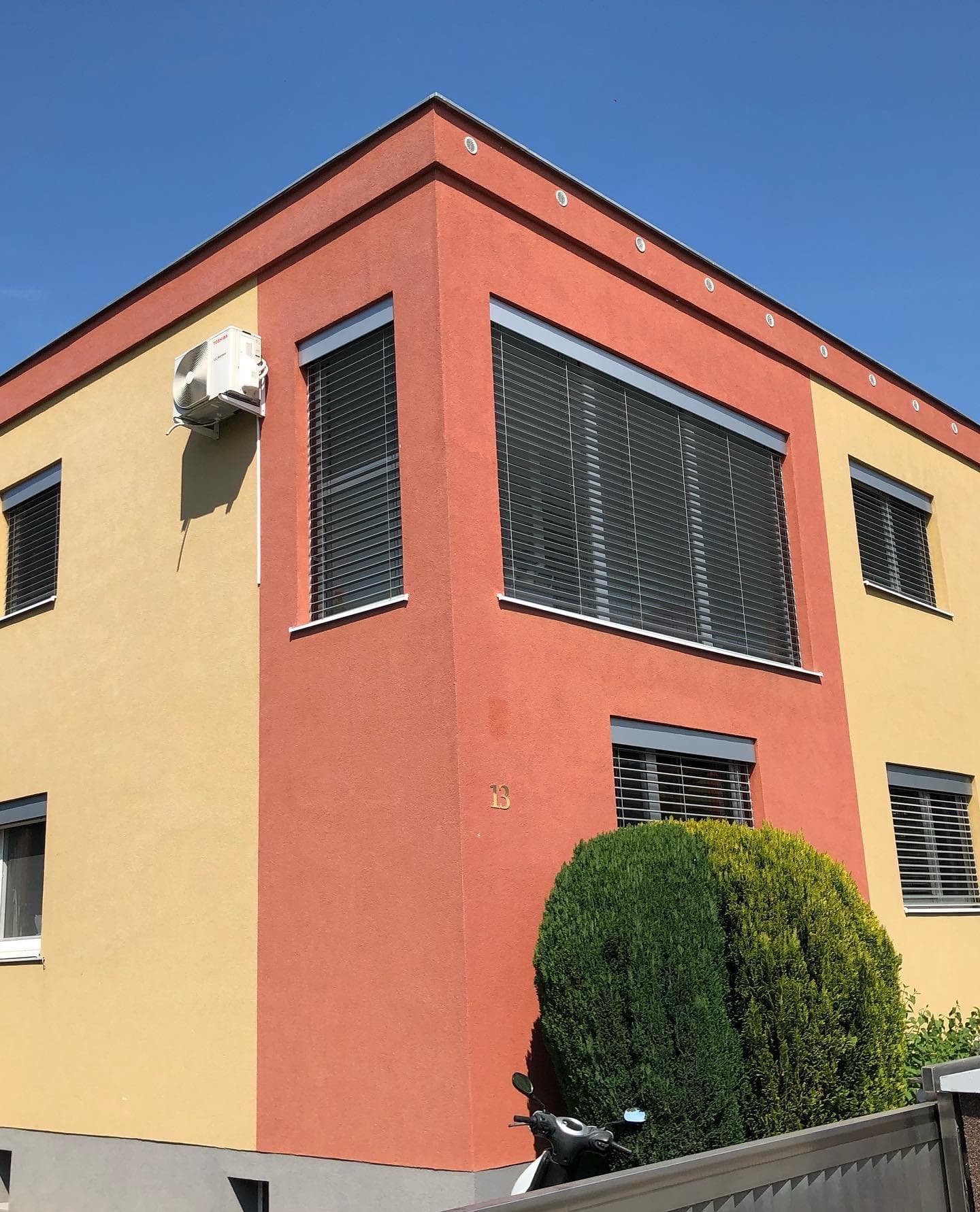 Dvojfarebná oranžovo-žltá fasáda rodinného domu, modré nebo